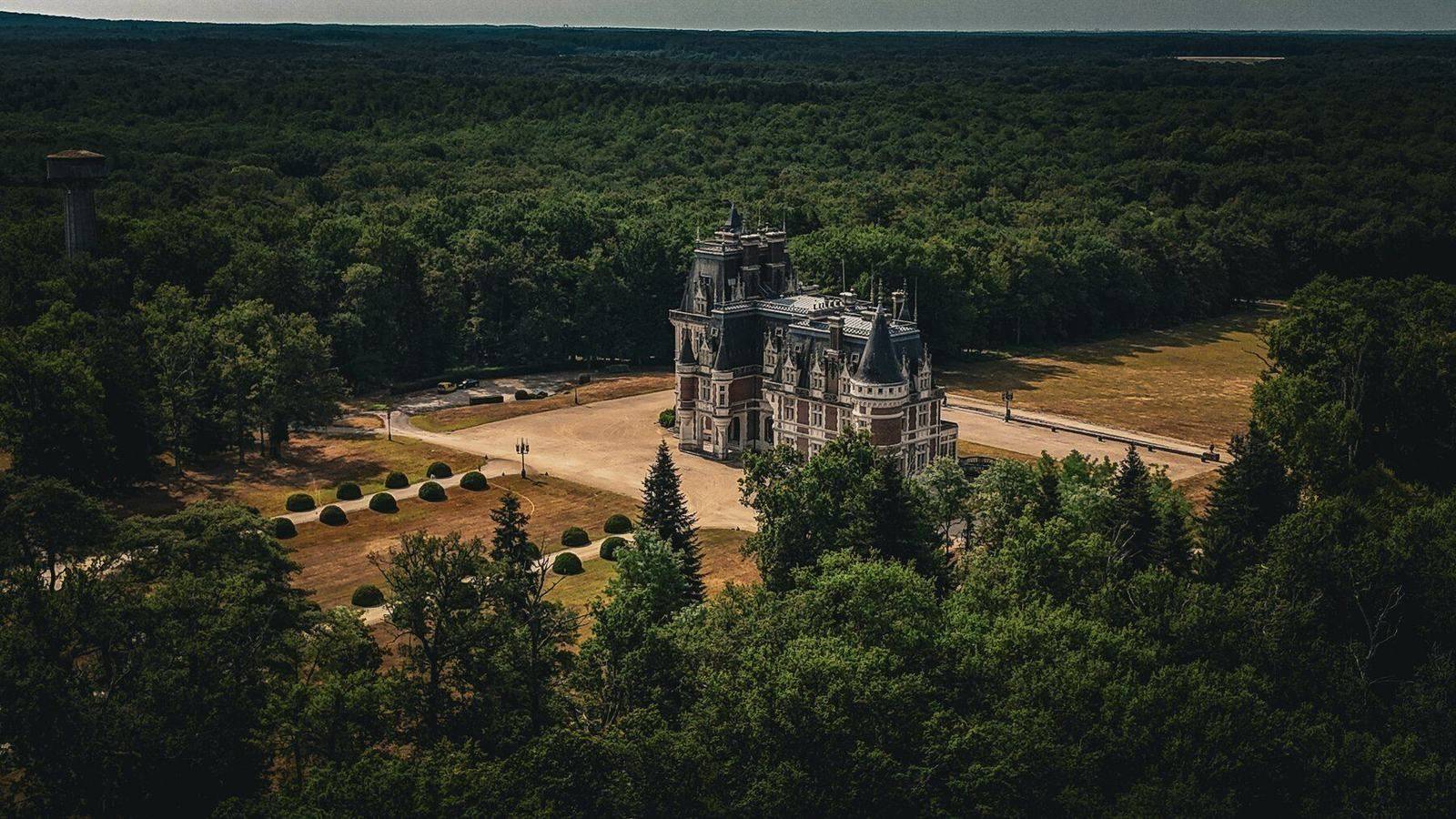 Aerial view of Château Changeux nestled within its forested estate